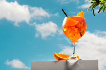 Glass of aperol spritz cocktail and blue sky. Copy space