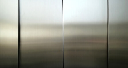 Stainless steel large sheet  With light hitting the surface  For background,Inside passenger elevator,Reflection of light on a shiny metal texture.