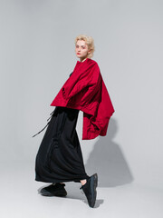 stylish blonde in a black dress with a red jacket