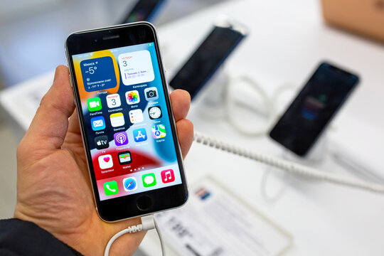 Smartphone Apple iPhone in hand. Buyer choosing smartphone in mobile phones Apple store. Minsk, Belarus - February, 2022
