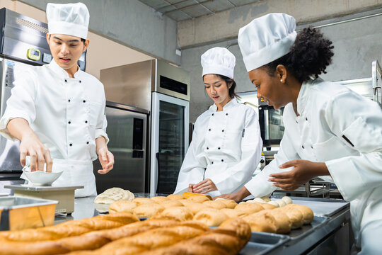 Asian Chefs  baker in a chef dress and hat, cooking together in kitchen.Team of professional cooks in uniform preparing meals for a restaurant in the kitchen.