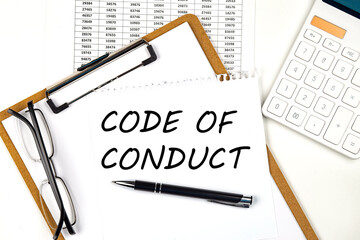 Text CODE OF CONDUCT on the white paper on clipboard with chart and calculator