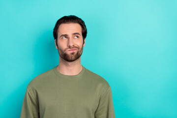 Fototapeta premium Photo of unsure brunet young guy look promo wear green pullover isolated on teal color background