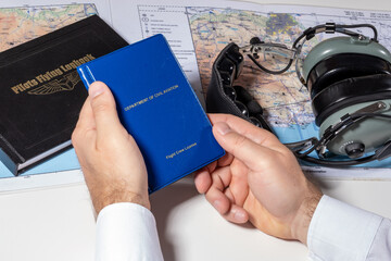 The pilot holds a civil flight license in his hands. Preparation of the route, drawing up a flight plan, filling in the necessary documents. The concept of a flight school and an airline.