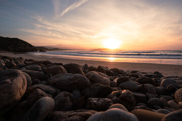 Rocky beach with round stones during sunset