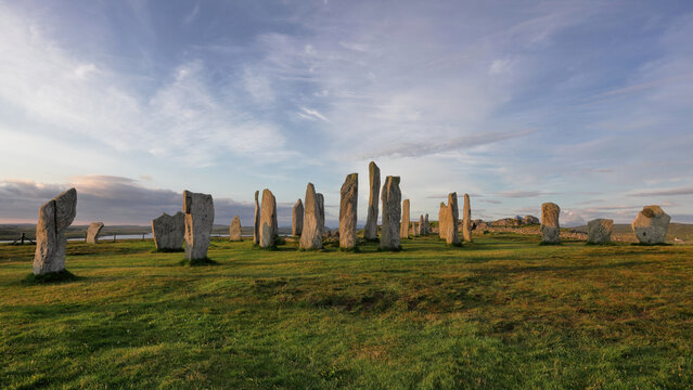 Callanish standing stones against blue cloudy sky at sunrise in Isle of Lewis, Scotland
