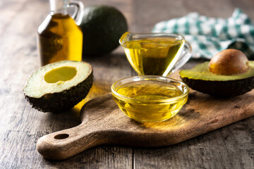 Oil and ripe fresh avocado on rustic wooden table	