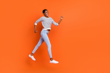 Fototapeta na wymiar Photo of funky hurrying third gender person wear pullover jumping running empty space isolated orange color background