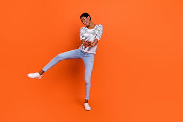 Fototapeta na wymiar Photo of funky pretty butch lady dressed sweater rising dancing smiling isolated orange color background