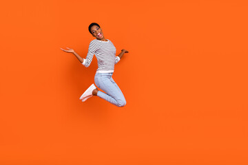 Photo of pretty sweet butch woman dressed sweater jumping high empty space isolated orange color background