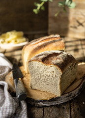 Front view the fresh loaf bread on a wooden cutting board with sunlights, rustic style