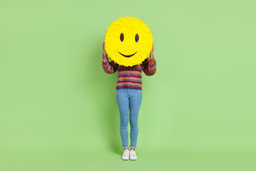 Photo of cute shiny lady dressed knitted pullover holding smiley cover face isolated green color...