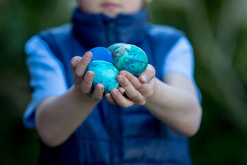 Child, holding colored eggs in garden