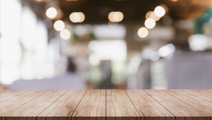 Empty wooden table top with lights bokeh on blur restaurant background.