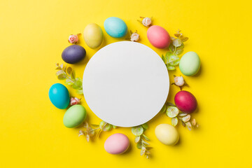 round frame multicolored Easter eggs with white blank paper on a brown background, close-up, space for text, blank for design, selective focus, tinted image