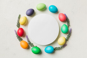 round frame multicolored Easter eggs with white blank paper on a brown background, close-up, space for text, blank for design, selective focus, tinted image