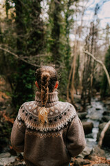Girl with a pigtail in a sweater from the back, a walk in the forest in nature . Cyprus troodos mountains