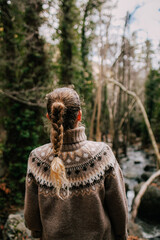 Girl with a pigtail in a sweater from the back, a walk in the forest in nature . Cyprus troodos mountains