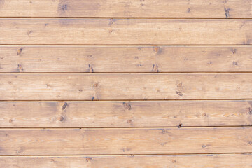 The polished wooden boards are fitted together. A table or fence, a wooden wall made of planks.