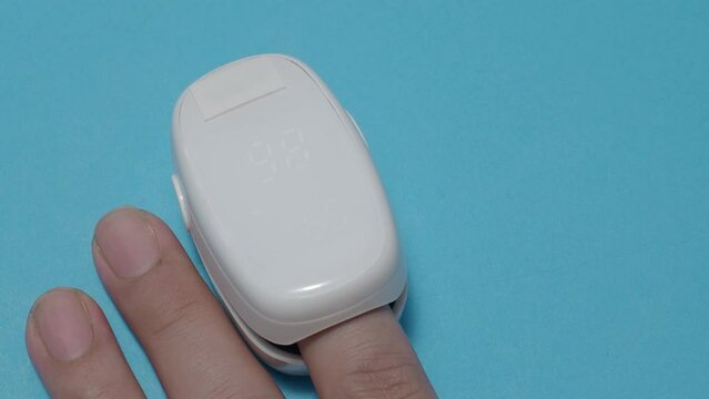 Oximeter usage. Finger pulse oximeter used to measure pulse rate and oxygen levels. Home self care during Covid 19 pandemic. healthcare monitoring concept. using portable fingertip pulse oximeter. 4k