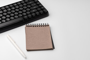 Minimalistic white workplace with keyboard and notebook