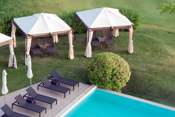 View of the pool with blue water, sun loungers and umbrellas.
