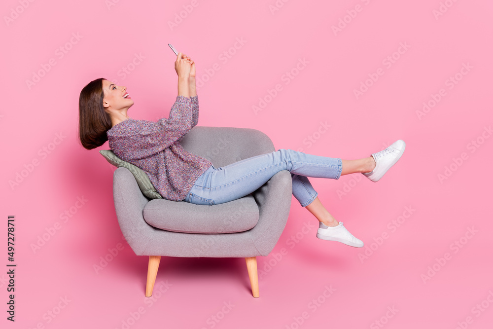 Sticker profile side view portrait of attractive cheerful girl sitting in armchair using device isolated ove