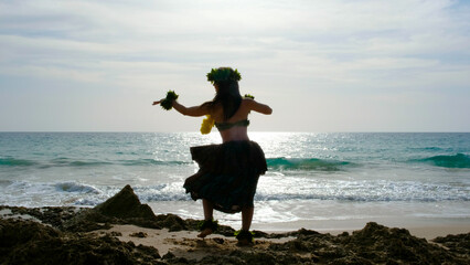 Happy and calm woman poses on the beach wearing the typical hula dance costume. Exotic beauty. Girl...