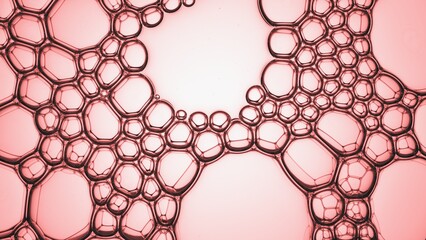 Macro shot of different sized bubbles joined each to other creating grid against pale pink...