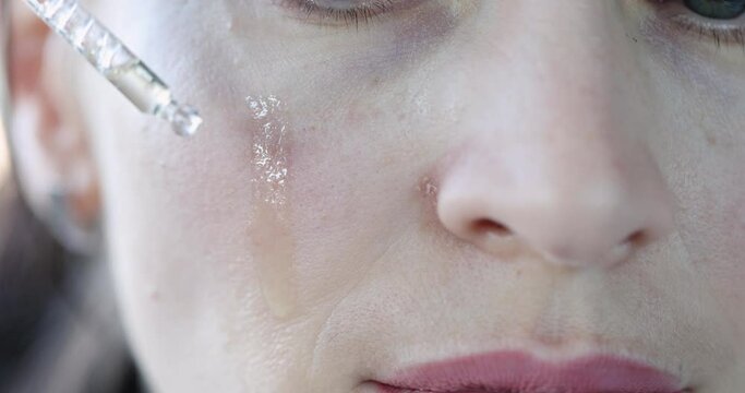Woman face drop of oil to moisturize skin closeup