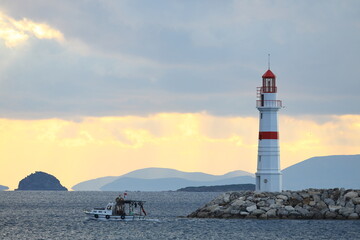 Seascape at sunshine. Lighthouse and sailings on the coast. Seaside town of Turgutreis and spectacular sunshine