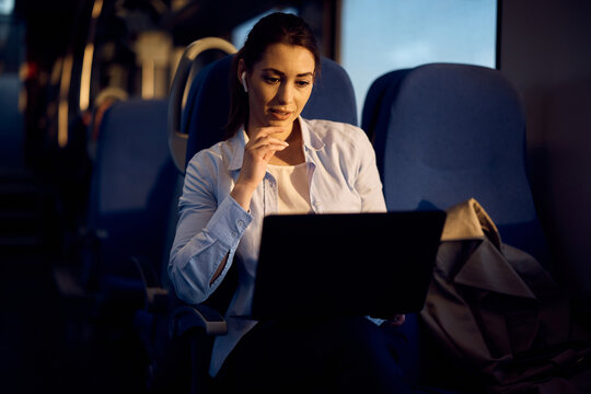 Female passenger uses laptop while traveling by train.