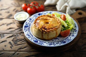 Traditional British meat pie with fresh salad