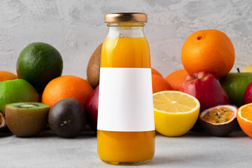 Various fruits and freshly squeezed fruits juice in bottle on gray background