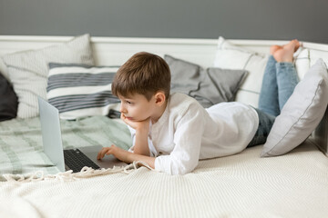 Cute little boy using laptop at home. Education, online study, home studying, distance learning, school boy children lifestyle concept