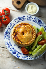 Traditional British meat pie with fresh salad