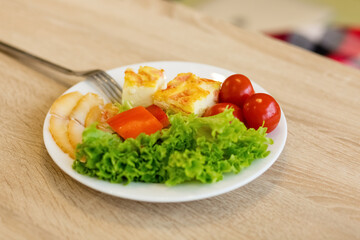 Lettuce leaves, tomatoes, omelet. Fresh vegetables on a plate. Proper nutrition, a healthy need for life.