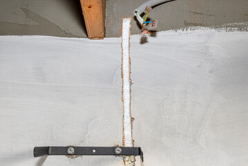 A furrow cut out in the facade of the house from polystyrene for an electric cable for connecting...