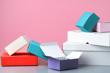 Set of cardboard boxes on pink background