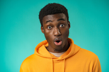 Afro american man over mint background shocked with surprise expression