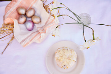 Easter background. Very peri and orange multicolored eggs, Easter cake and narcissus flowers. Easter holidays background. Good mood. Copy space. Top view.