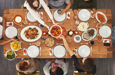 Memories are made when gathered around the table. Shot of a group of people sitting together at a dining table ready to eat.