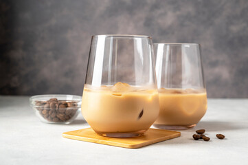 Irish cream liqueur in a glass with ice cubes and coffee beans