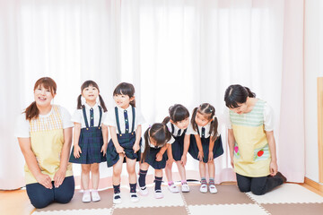 Obraz premium 発表会の練習をする子どもたちと保育士