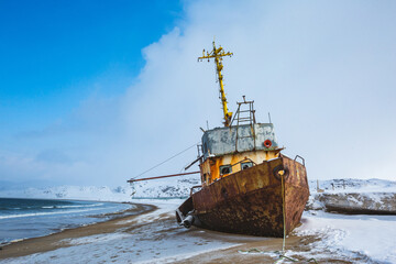 Ship washed ashore near Teriberka, Barents Sea bay. Winter landscape. Russia