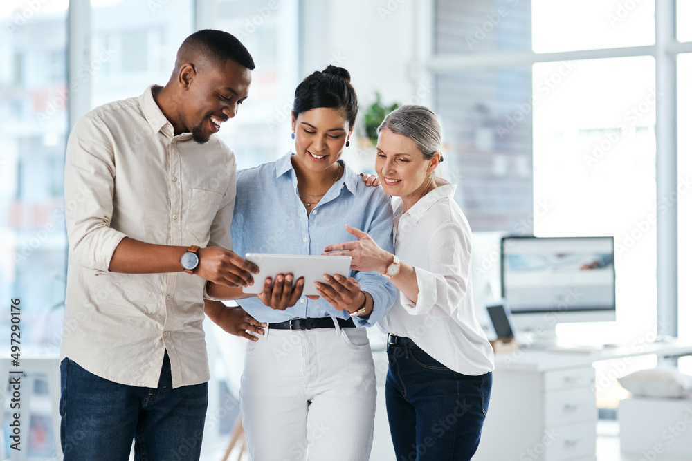 Poster Using online resources to their advantage. Shot of a group of businesspeople using a digital tablet together in an office.