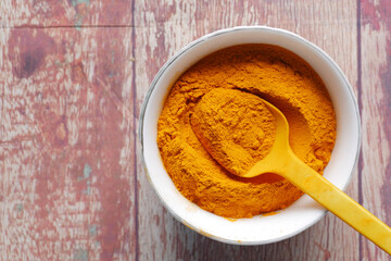 top view of turmeric root powder in bowl on table ,