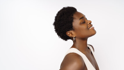 Fototapeta na wymiar Beautiful black woman . Beauty portrait of african american woman with clean healthy skin on beige background. Smiling beautiful afro girl.Curly black hair