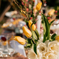 Festive setting with beautiful tulips on dining table served for Easter celebration