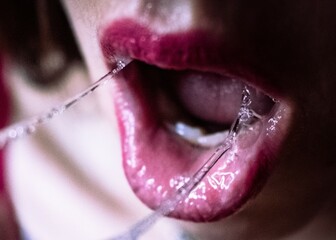 Upclose woman's mouth with saliva and red lipstick - obrazy, fototapety, plakaty